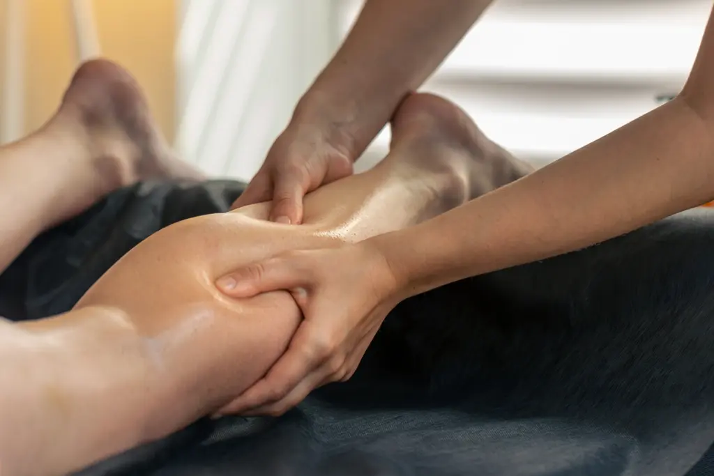 standing-office-yoga-workout-workout Sportmassage: Hände kneten die Wade eines liegenden Sportlers