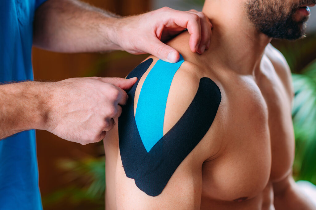 standing-office-yoga-workout-workout Kinesiologisches Tape wird auf die Schulter eines Mannes geklebt